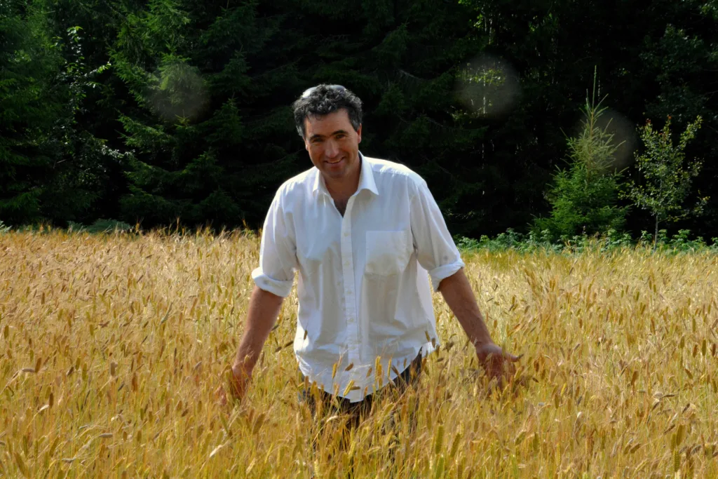 Petter Simonsen er glad i å kjenne på kornet. Han berømmer det biodynamiske miljøet for planteforedlingsarbeidet.