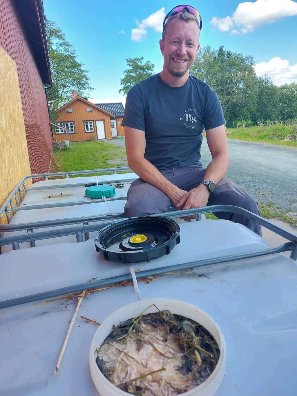 I andelslandbruket på Søndre Reppe gård ved Trondheim viser Lars Olav Stavnes frem neslevann som brukes som gjødsel. Neslevannet framstilles i en stor plasttank. Neslene er tilsatt litt surmelk for bedre gjæring. Foto: Grete Lene Serikstad